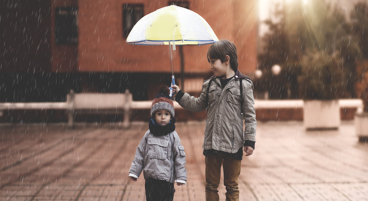 Brother holding umbrella for his younger brother ; image used for HSBC Philippines HSBC Safeguard