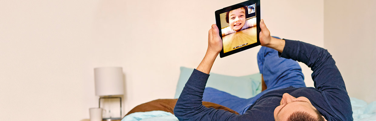 Father video calling his child on ipad; image used for HSBC Philippines Advance Online Tools page
