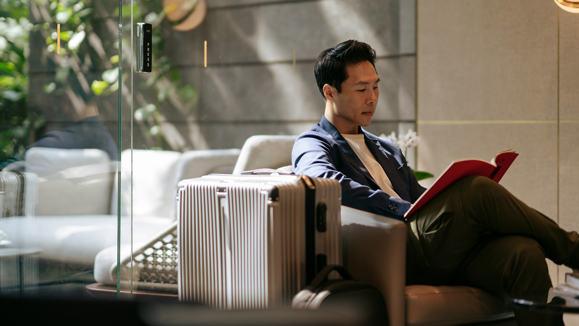 man with suitcase sitting at lounge