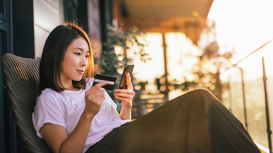 Woman sitting in her balcony; Image for 'What is credit score?' article