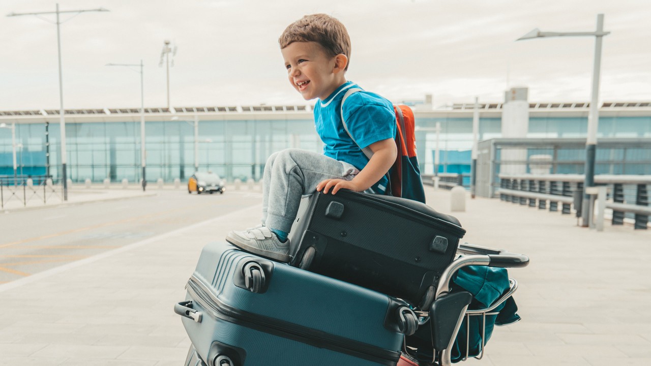 a boy is sitting on the suitcase carrier; image used for HSBC Philippines Credit Card single girl offer page