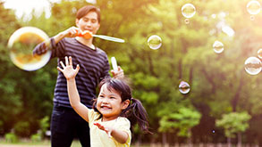 Father blowing bubbles; image used for HSBC Card Balance Transfer page