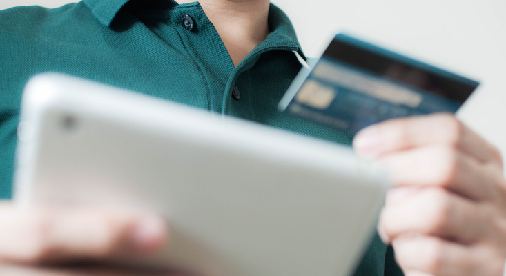 Man holding credit card and phone; image used for HSBC Philippines Fraud guide page