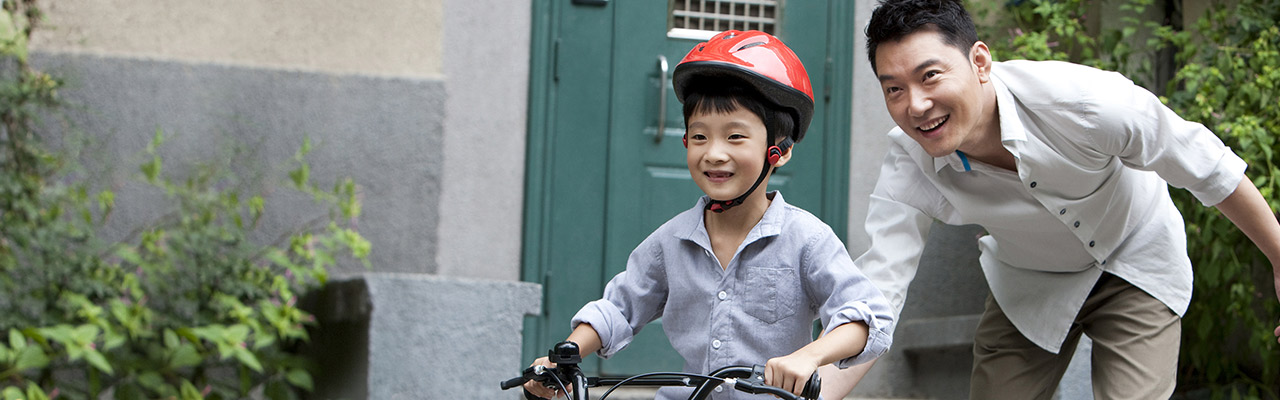 Father teaching his son how to ride a bicycle; image used for HSBC Philippines Insurance