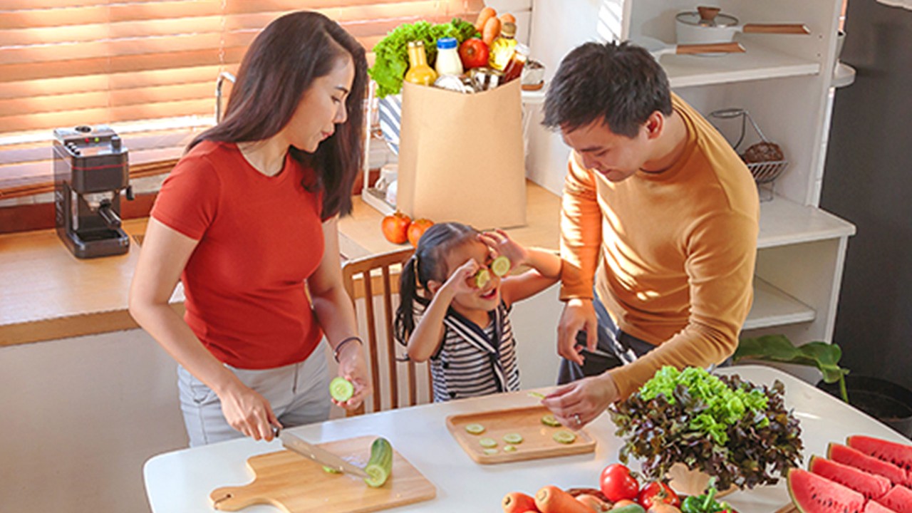 Family unpacking groceries and cooking together