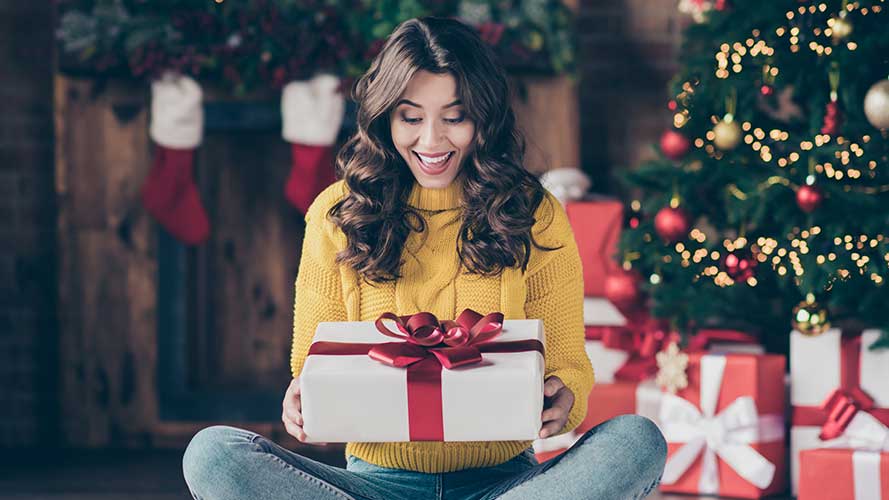 Woman holding up Christmas present; image used for HSBC Philippines Christmas 2020 Promotion page