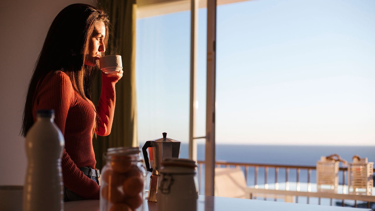 woman coffee looking through window