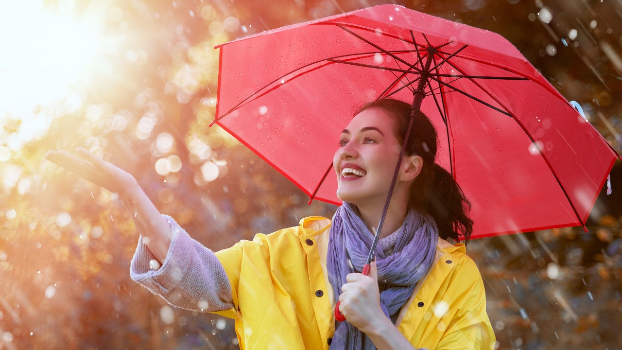 Woman holding a red umbrella in rain; image used for HSBC Philippines Credit Cards Offers Free for Life Single Girl page