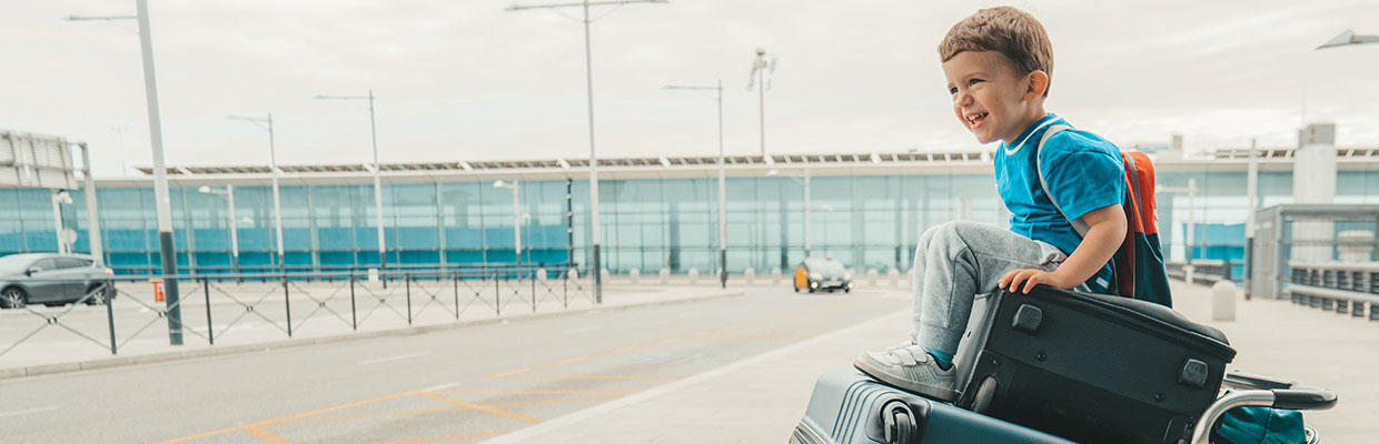 Boy sitting on luggage trolley outside of airport; image used for HSBC Philippines Credit Cards Offers Hong Kong Trip via Cathay Pacific page