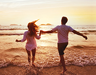 Couple jumping into ocean