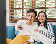 Couple snuggling on couch watching tv