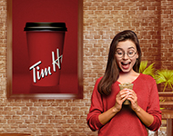 Women excitedly holding a Tim Hortons drink