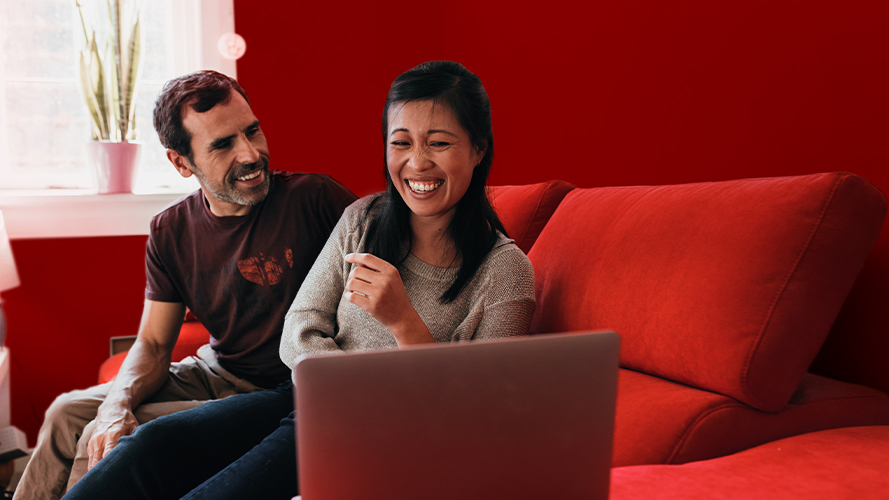 Couple laughing in couch; Image used for HSBC  Global investment opportunities page - Grow your wealth through foreign investments and expand your investment opportunities 
