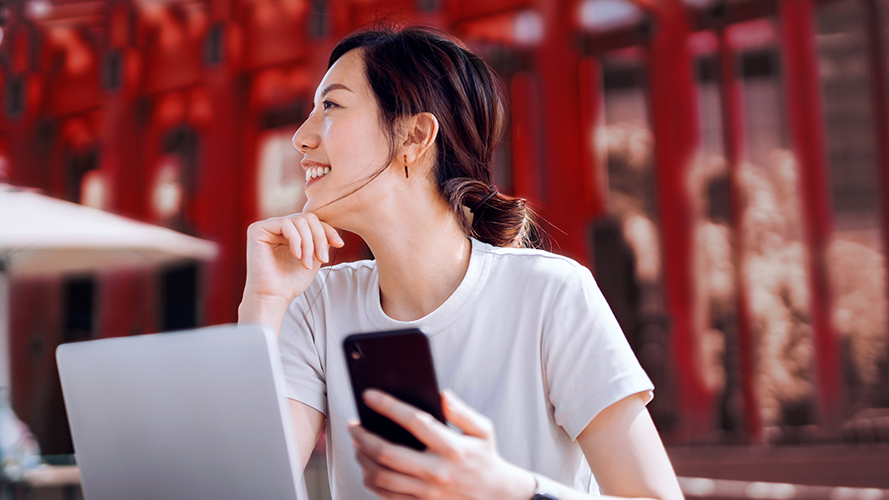 Woman smiling while holding her phone; Image used for HSBC Premier Overseas Education page - Take the first step in studying abroad