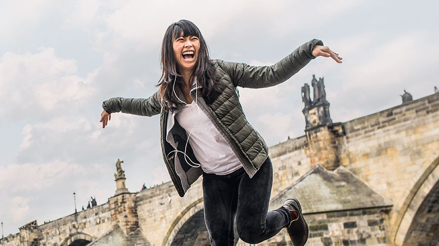 Woman jumping in front of a bridge; image used for HSBC Philippines Premier International Connectivity page